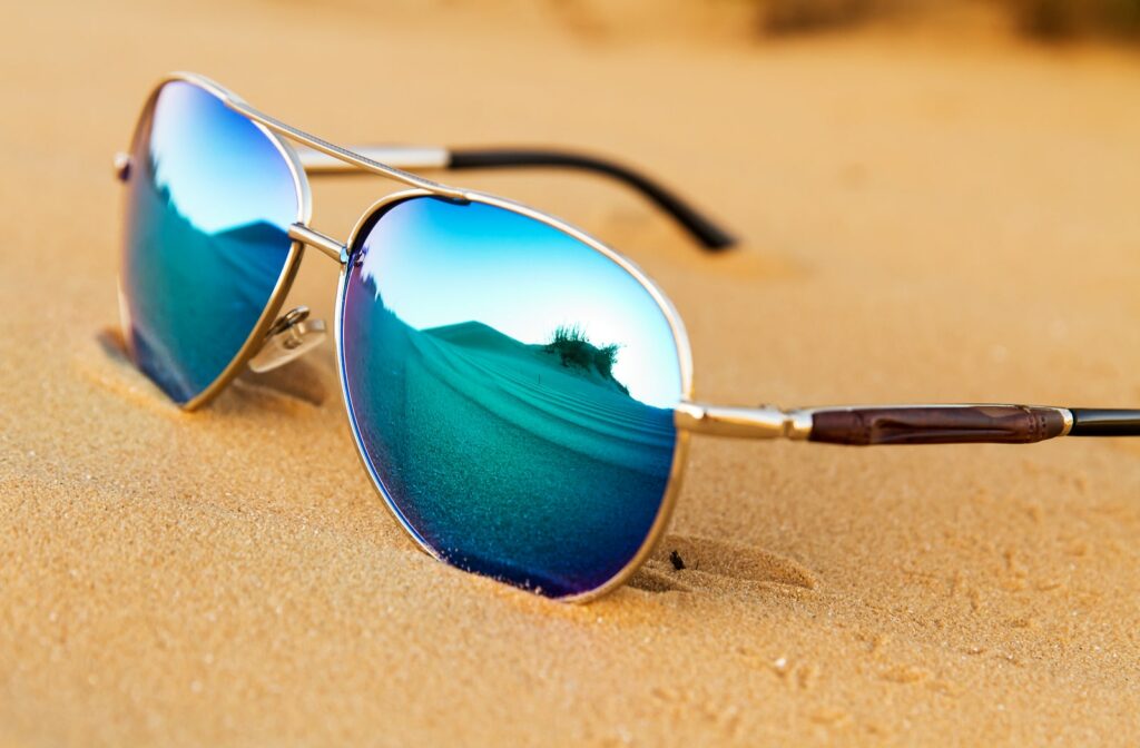 A pair of polarized sunglasses sitting in the sand