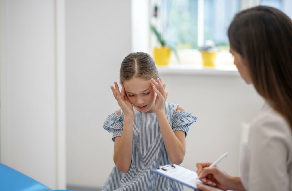 A young girl complaining of eye pain and headaches during a visit to an optometrist