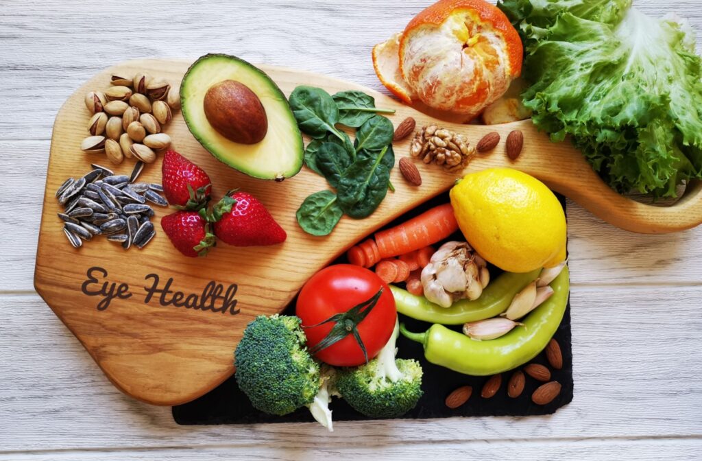 An array of healthy foods lay on a wooden platter with "Eye Health" written on it.