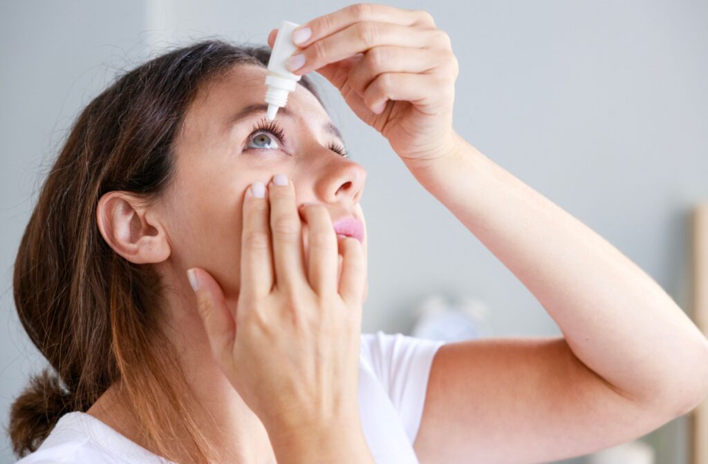 A person putting in eye drops to help soothe their eyes from allergies