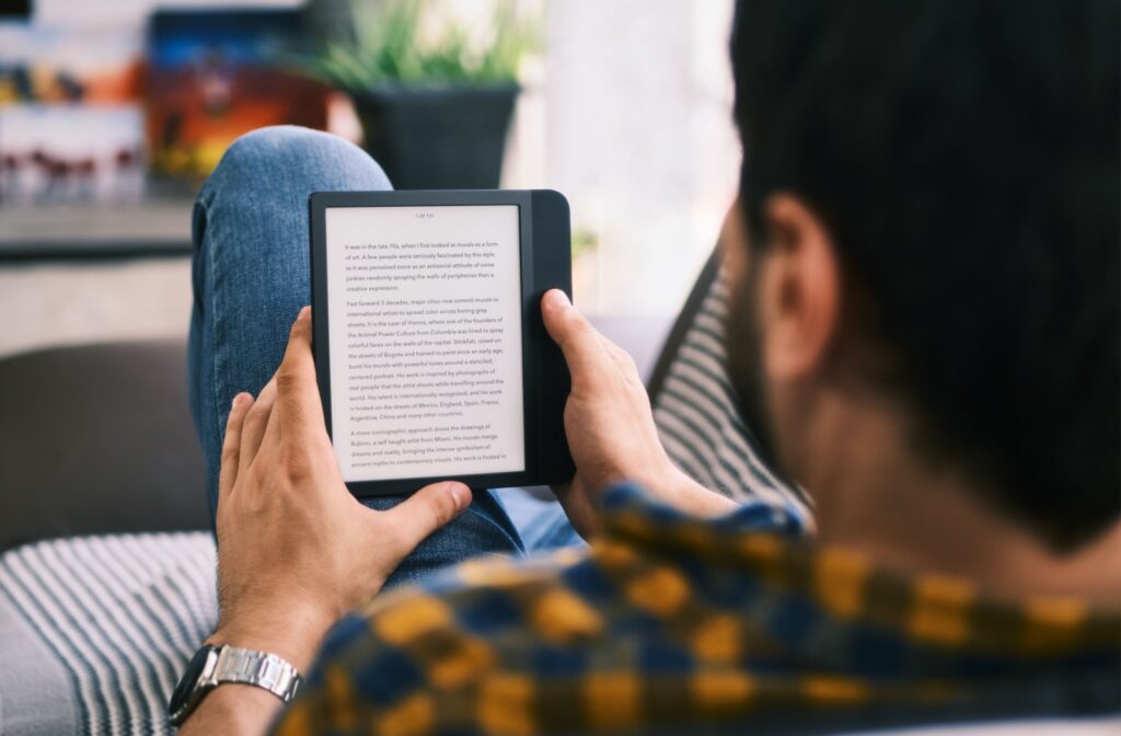 A person holding an e-reader reading a e-book.
