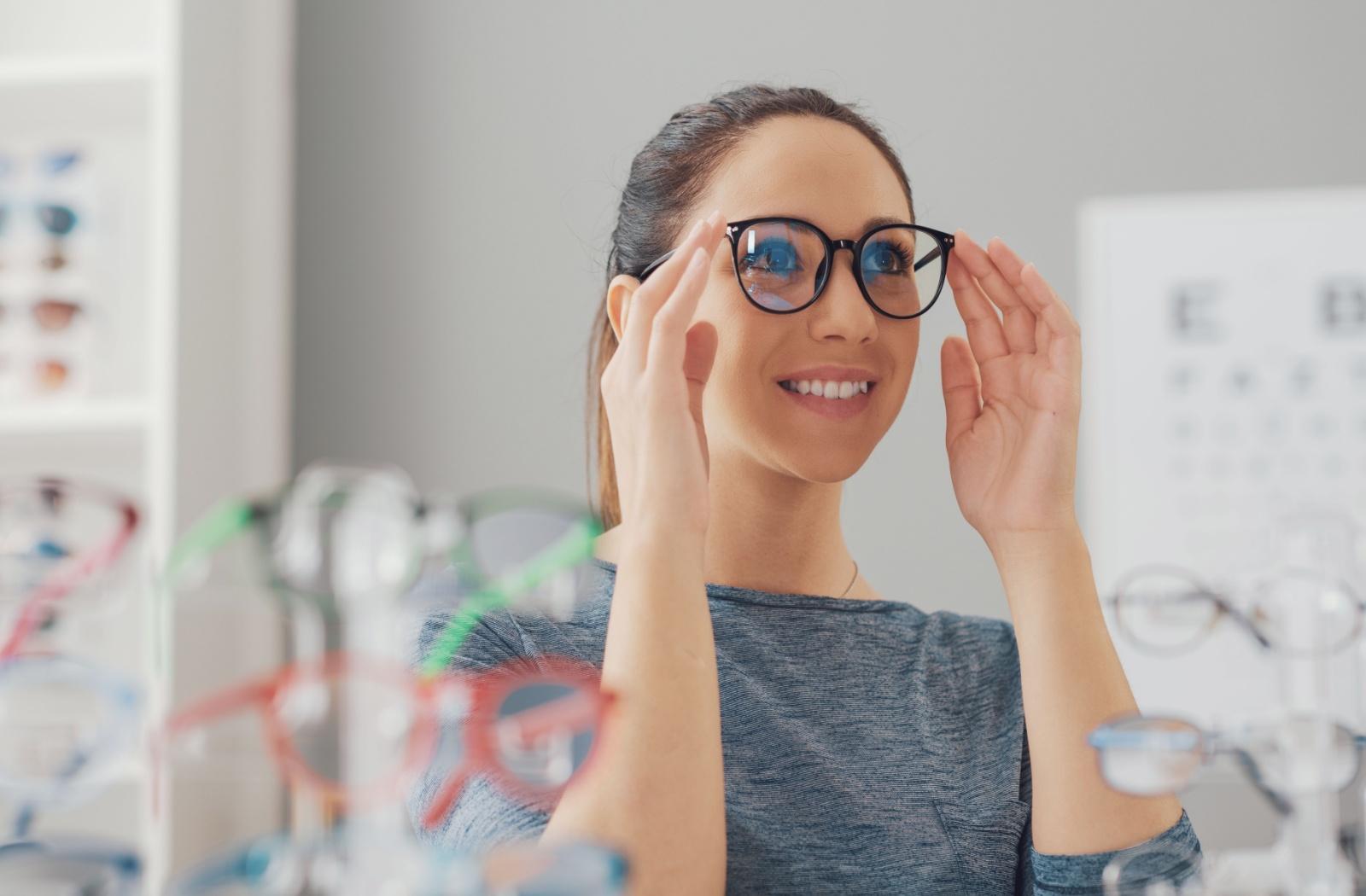 A patient trying on a pair of glasses at their optometrist's office to see if the style of frames suits their face.